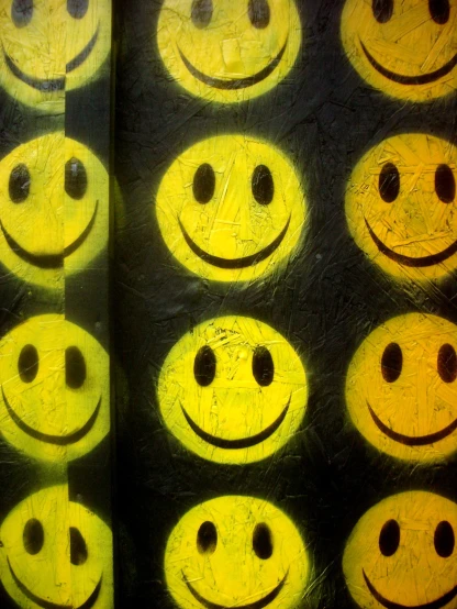 many different yellow smiley faces are arranged next to each other