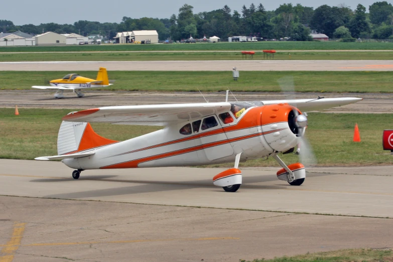 an orange and white airplane is on the runway