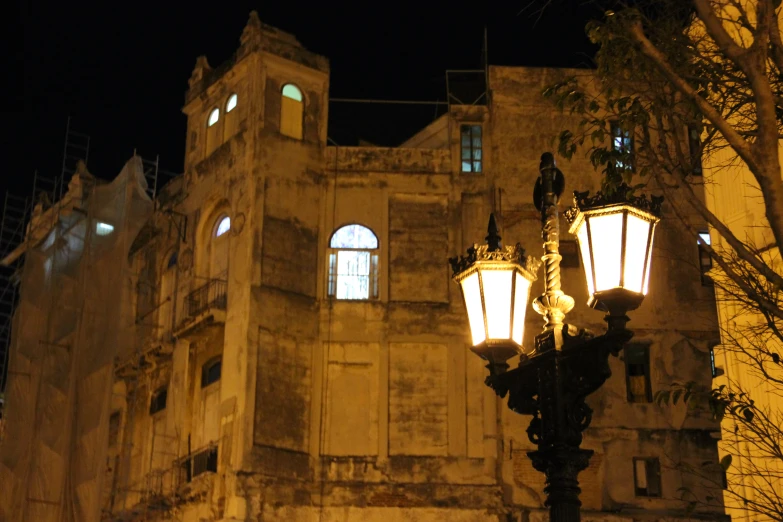 old building with stone facade at night time with lit street lights