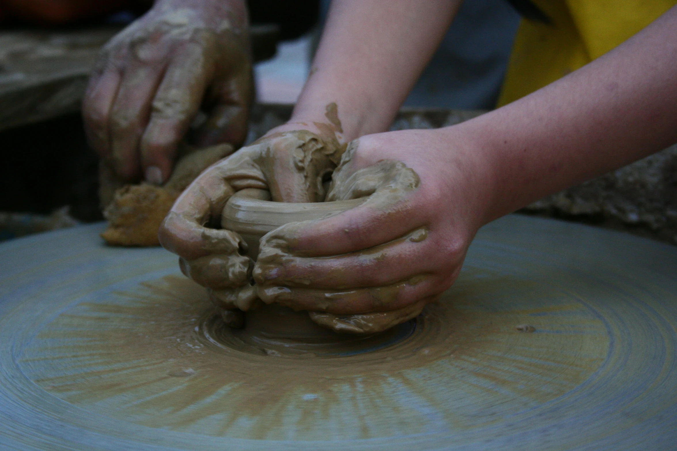 a person working with clay in a pottery class