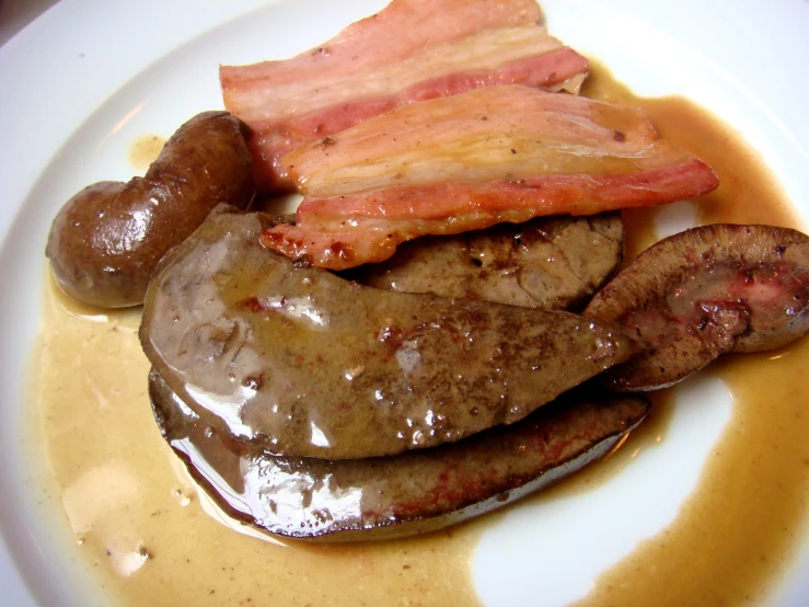 a plate topped with meat and vegetables covered in gravy