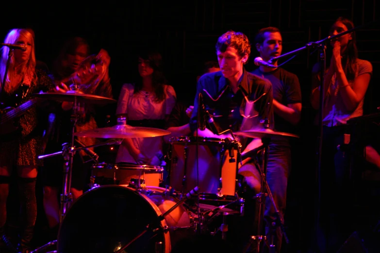 people are gathered around a band performing on stage