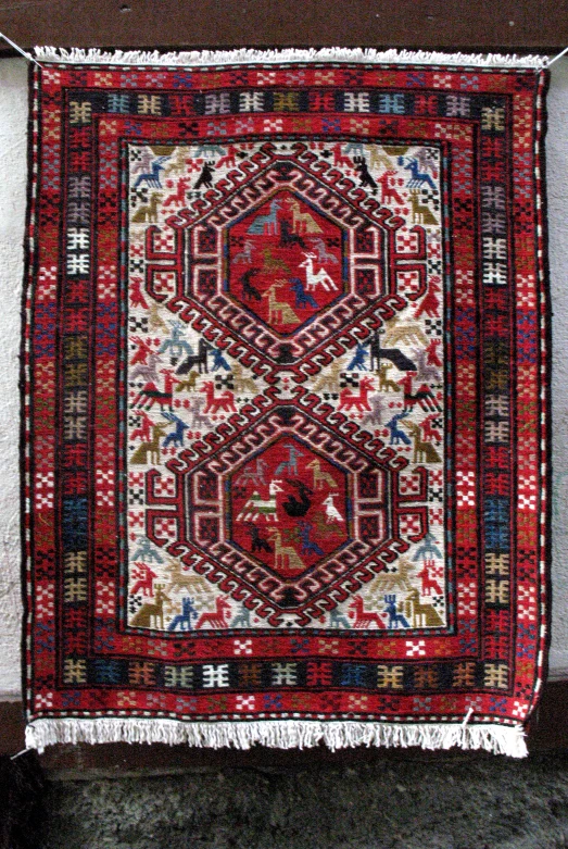 an old, oriental rug is hung on a wall