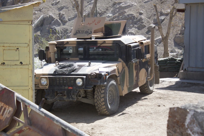 a military vehicle in front of a yellow building