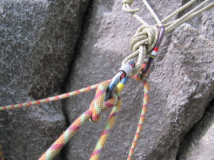 a rope connected to a rock face next to a knot