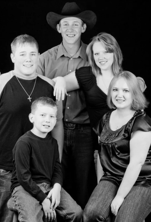 a group of people wearing cowboy hats pose for a picture