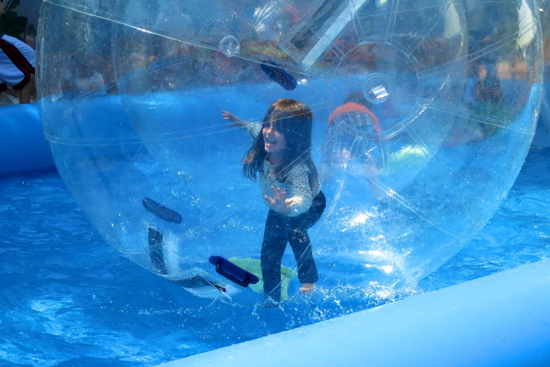 a little girl is in a water ball