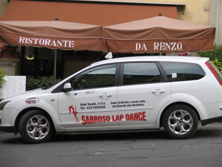 a small white car with an advertising on it