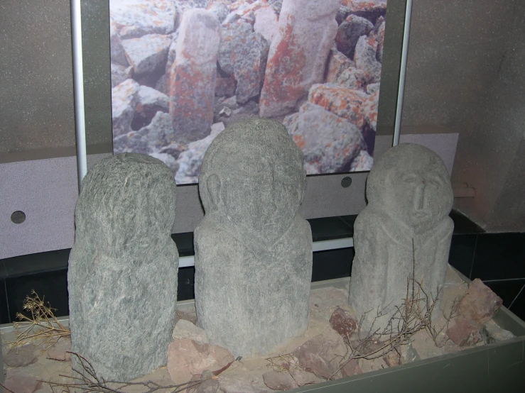 four boulders sitting in a niche with rock artwork