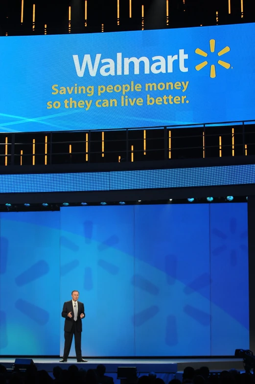 man on stage at walmart delivering a presentation