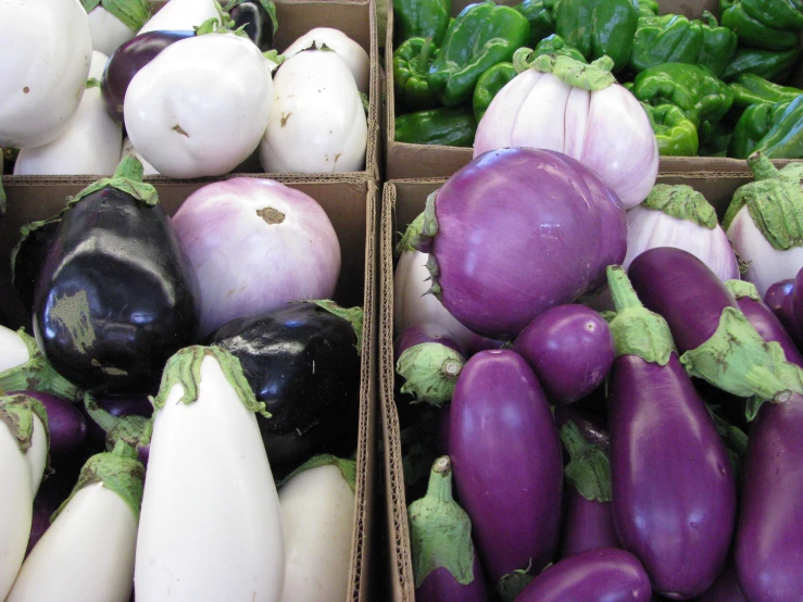 a couple of boxes filled with lots of purple and white vegetables