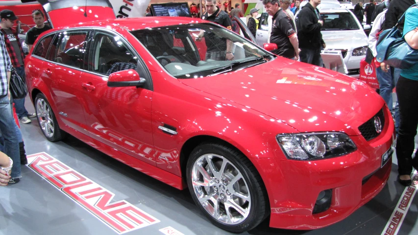 a red car is on display at the auto show