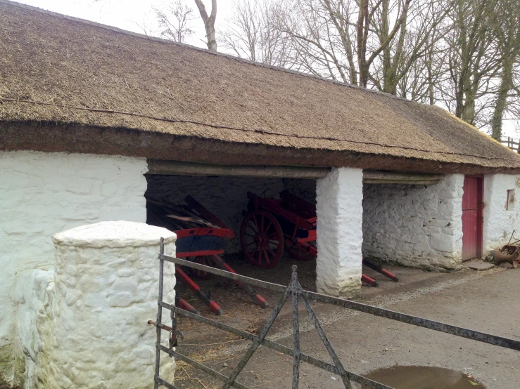 a small building with two horses drawn carriages