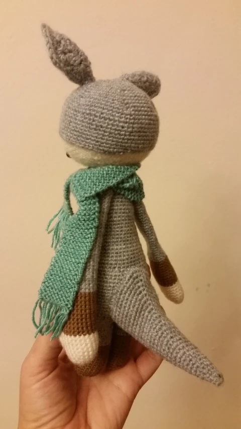 an old knitted toy that has some green scarves