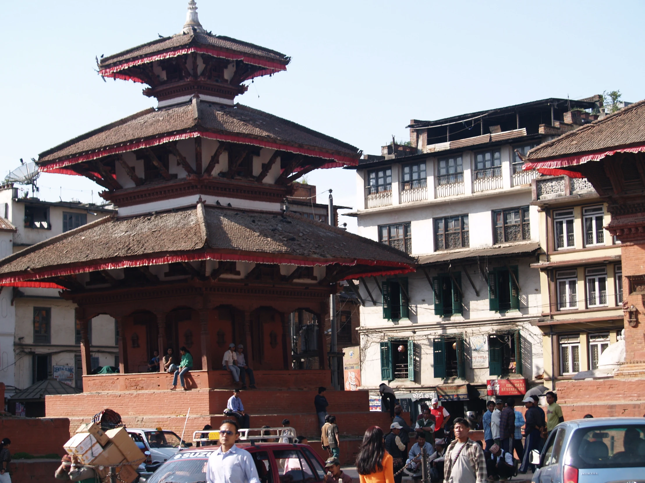 several people standing outside a building that has several story like structures