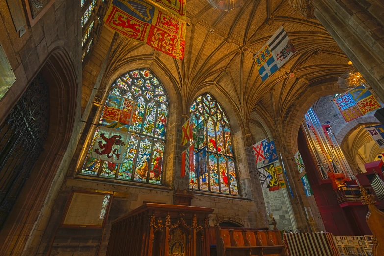 the ceiling in this church has ornate, multi - colored stained glass windows