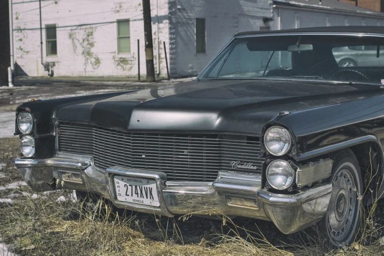 an old car is parked on the grass