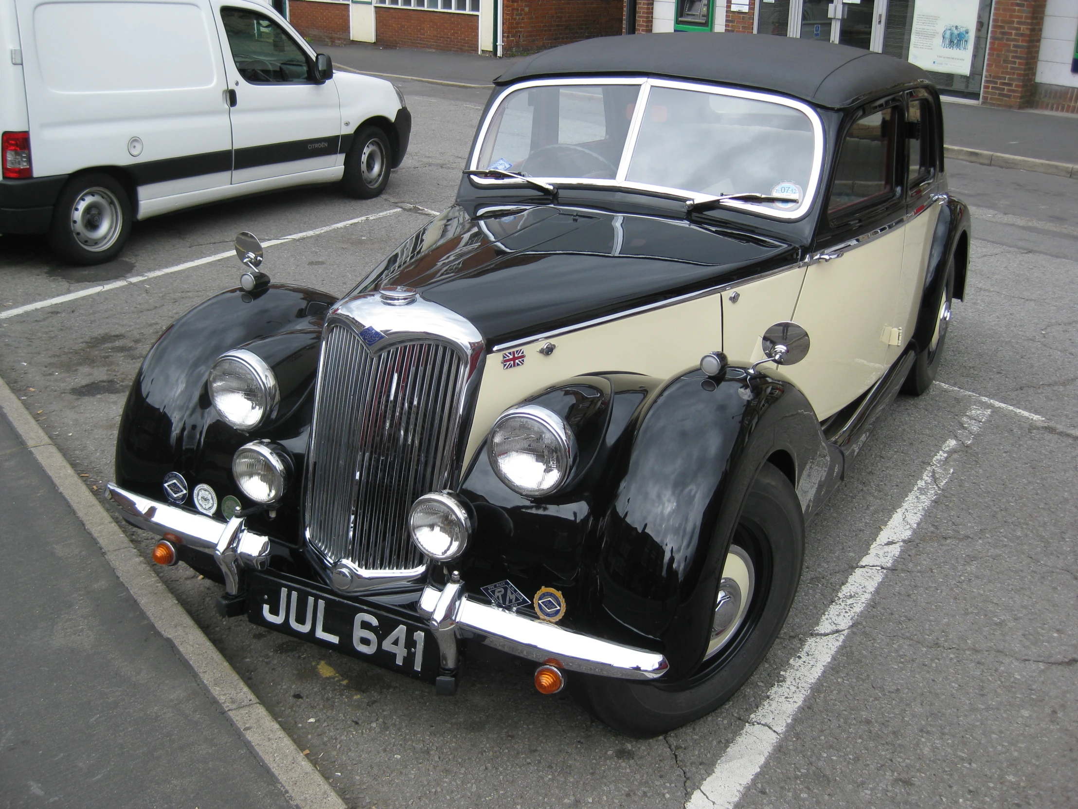 an old fashioned car is parked at the curb