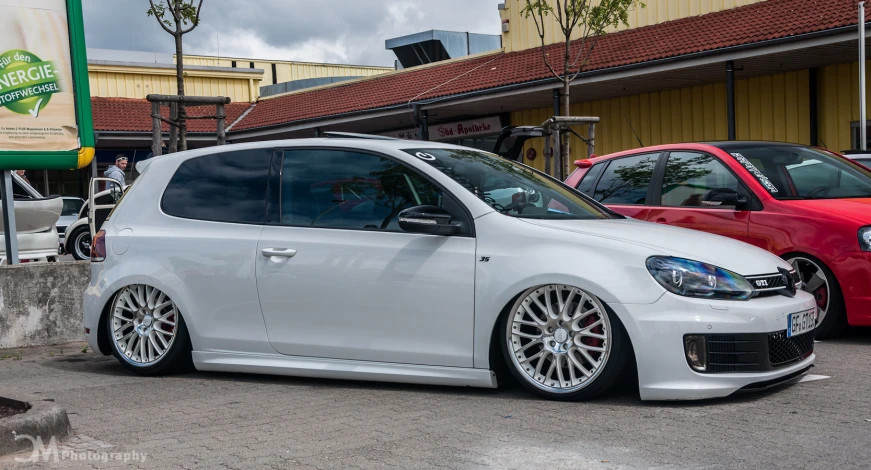 a white volkswagen type wagon with chrome wheels