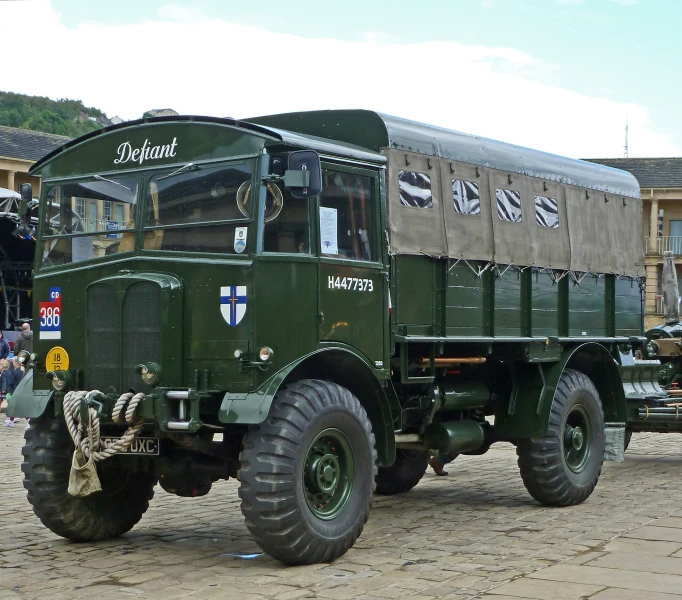 large military green truck parked in a dirt field