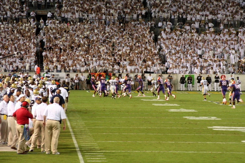 two football teams are playing on the field