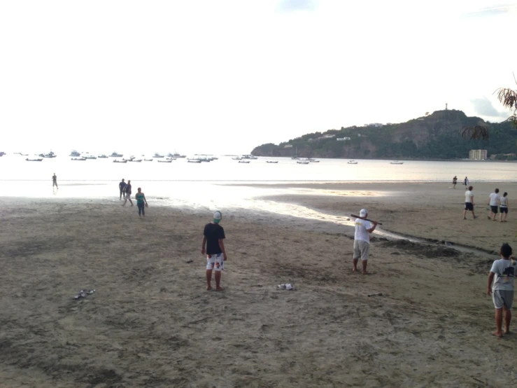 a group of people standing on top of a beach