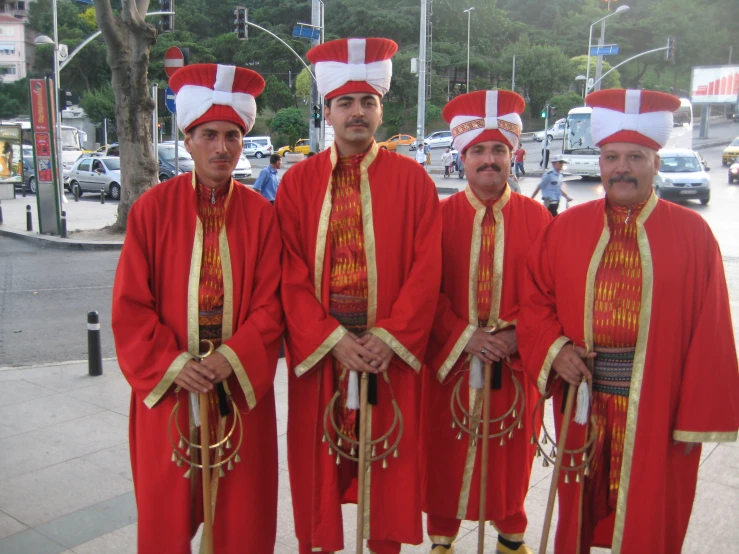 several men dressed in red and gold attire