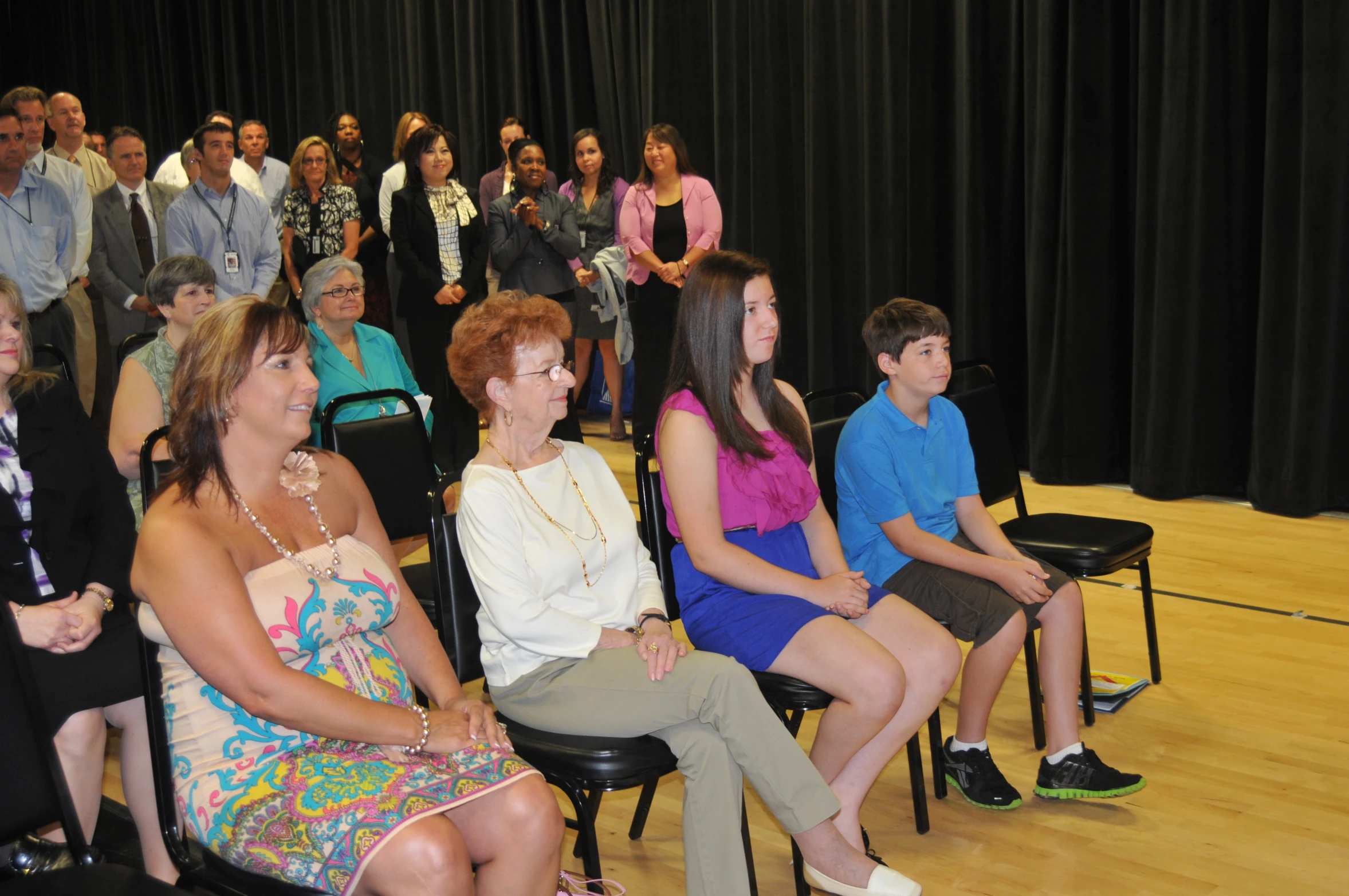 a group of people sit in a circle on chairs