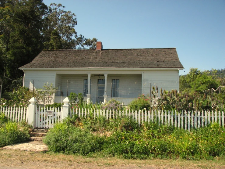 a white house in a small neighborhood with fence