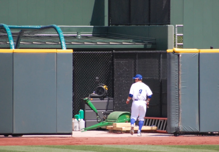 the baseball player is leaving the dugout in preparation for the next pitch