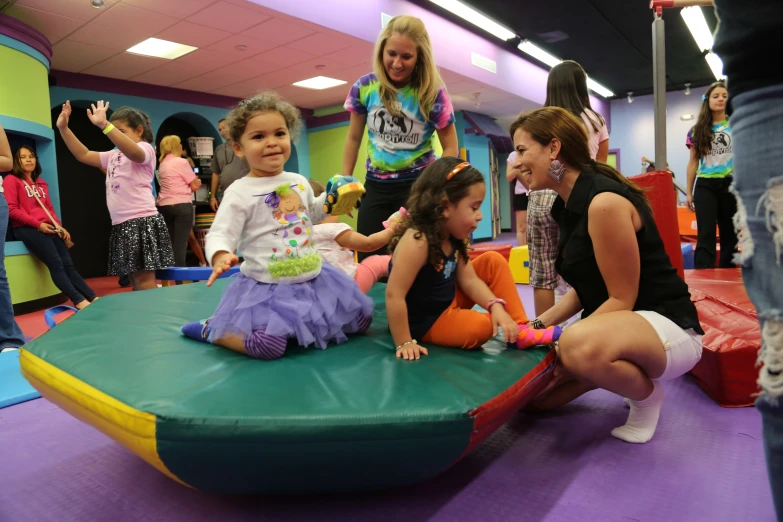 some little girls sitting and talking together in an indoor play area