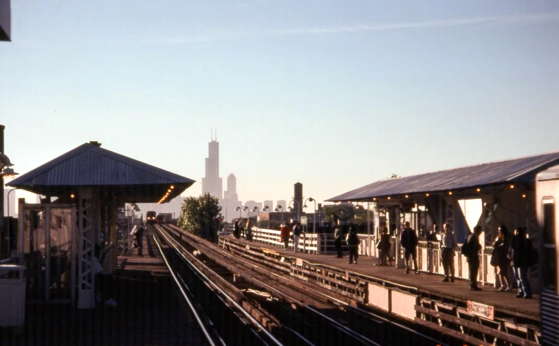 people are standing on and off the train tracks