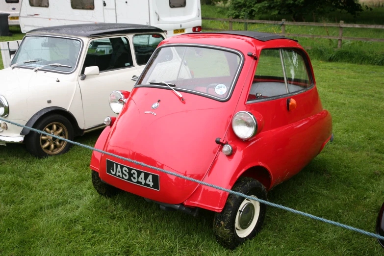 red car with sidecar in grass with two white cars