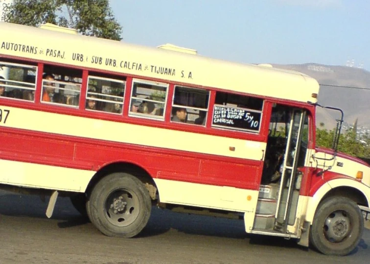 a bus is driving down the road near trees