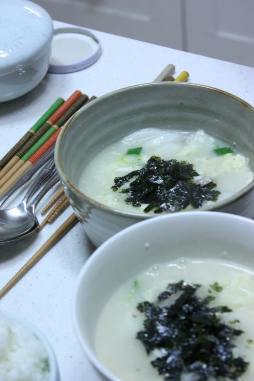 bowls filled with a lot of food and chopsticks next to them