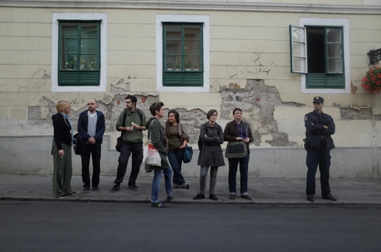 a group of people stand against the wall