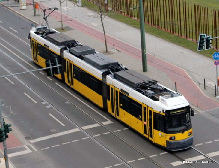 a yellow and white train traveling down tracks