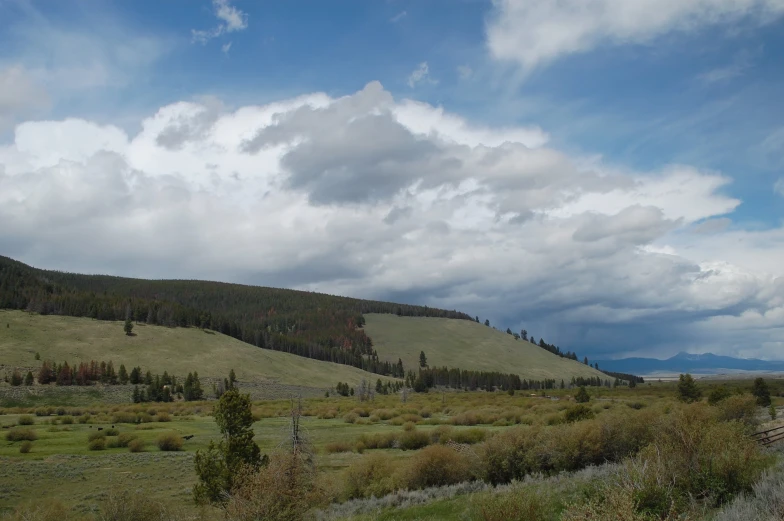 a cloudy blue sky and some mountains on a clear day