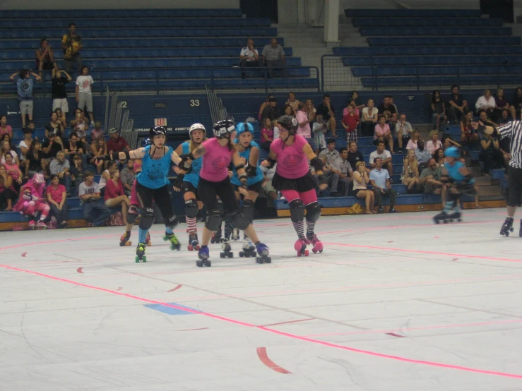 the women in pink shirts are rollerblading with other people