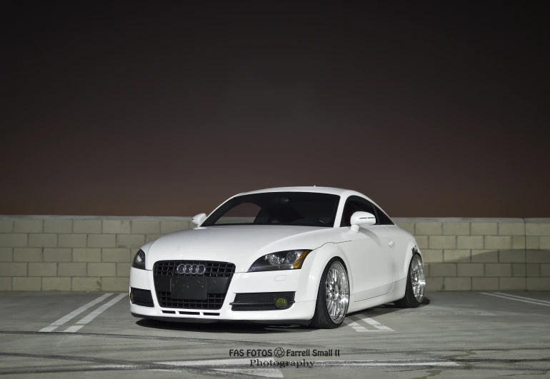 a white sports car parked in a parking space