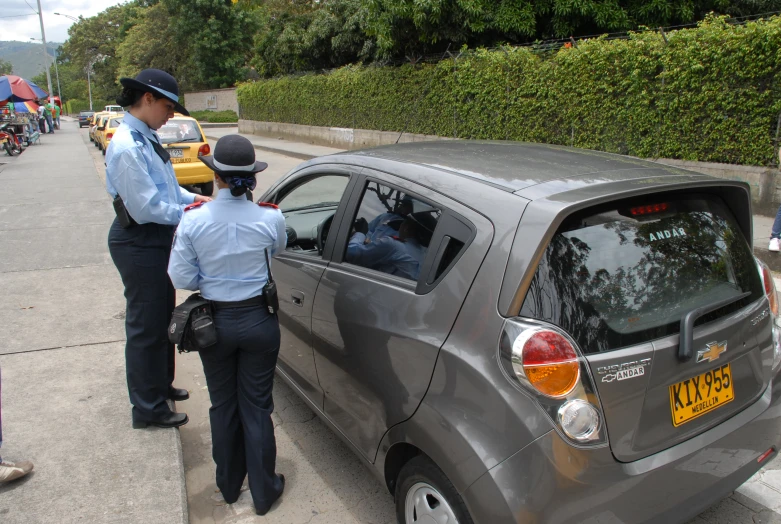 two people with traffic enforcement standing beside a car