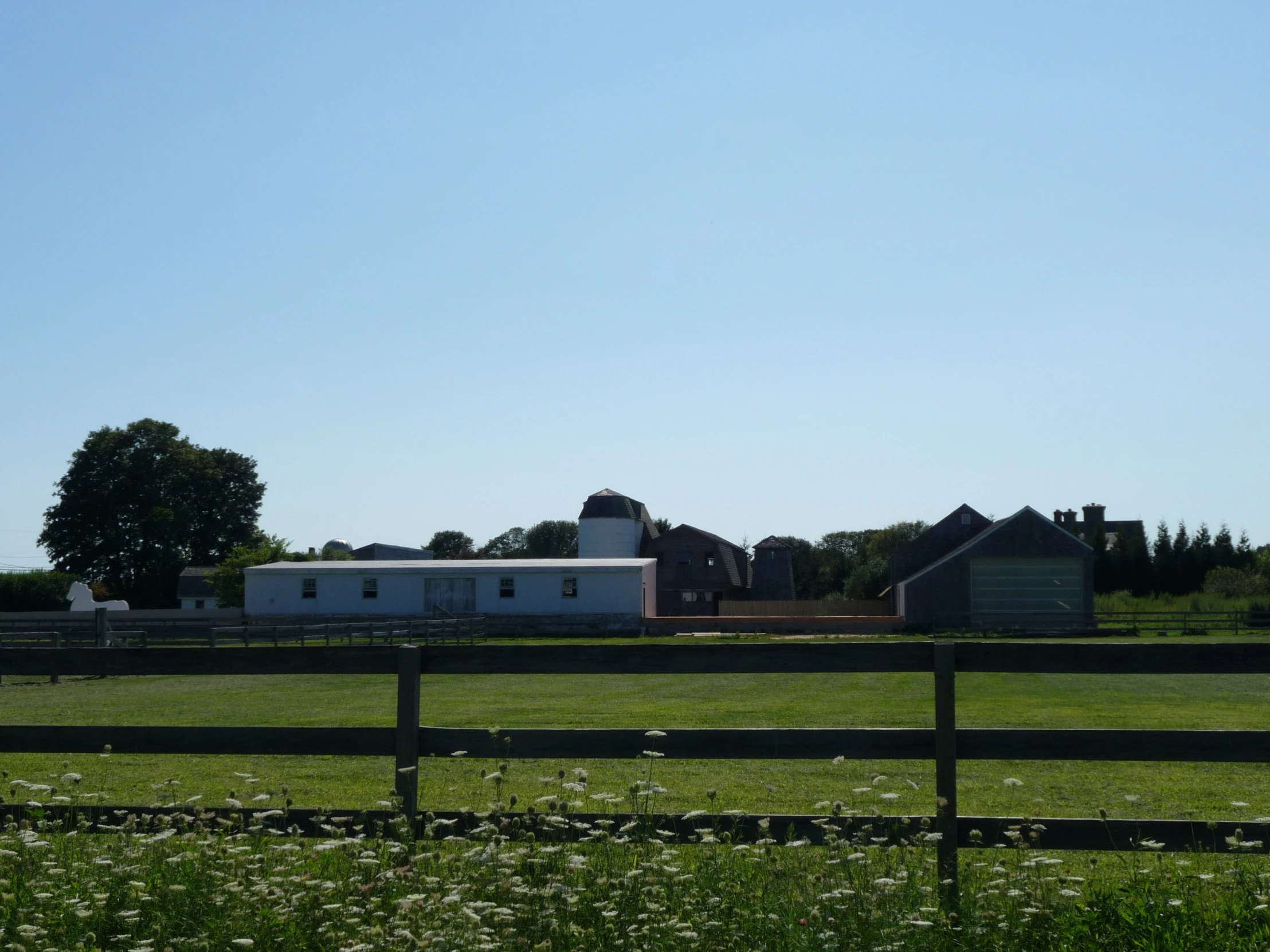 a barn sitting beside a fence and some trees