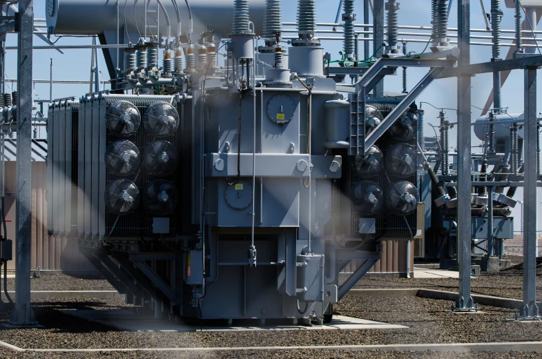 large group of electrical equipment on ground with sky background