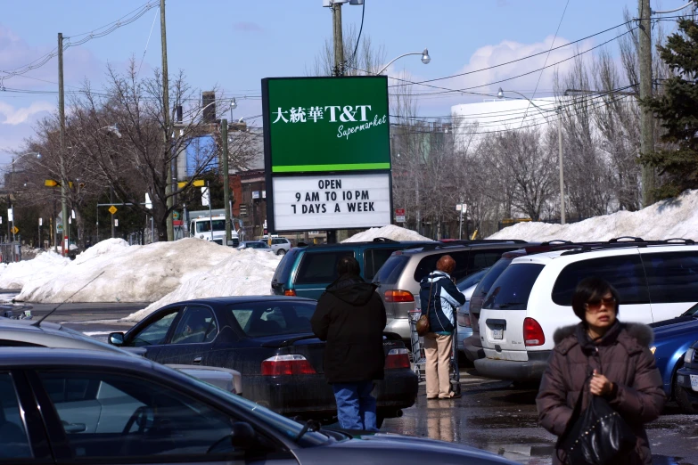 a group of people walk across a parking lot