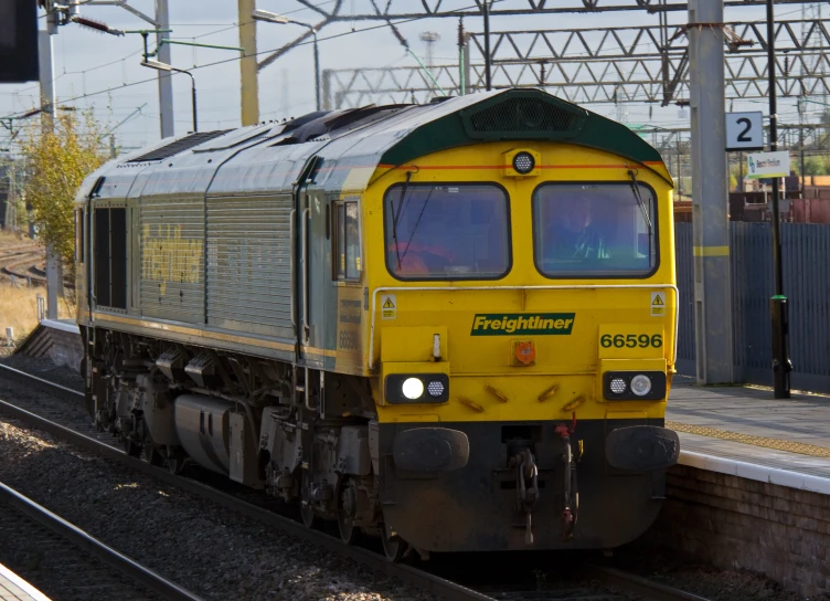 a yellow and green train on the track