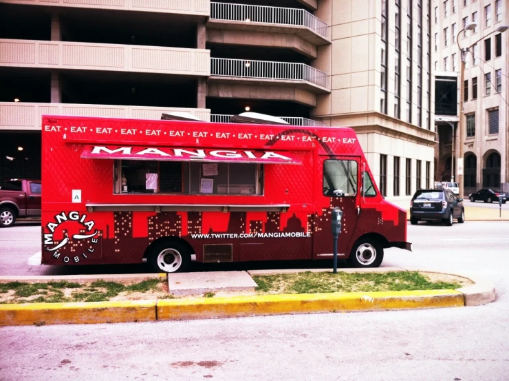 a red truck parked in front of a tall building