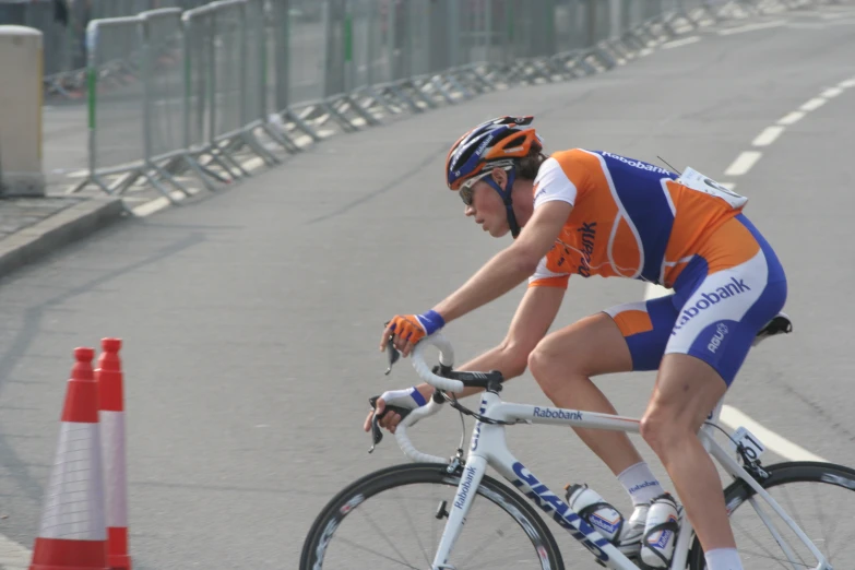 a man riding a bicycle wearing orange and white shirt