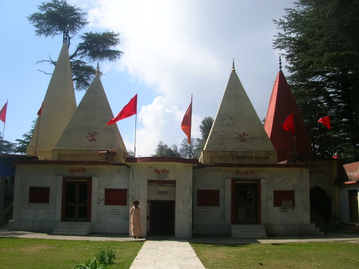 a very nice white building with red flags on top of it