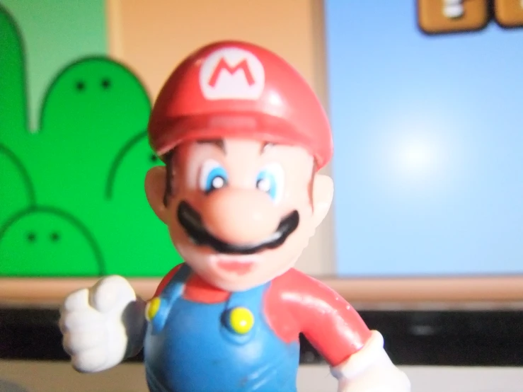 a toy mario brothers character holding soing in its hand