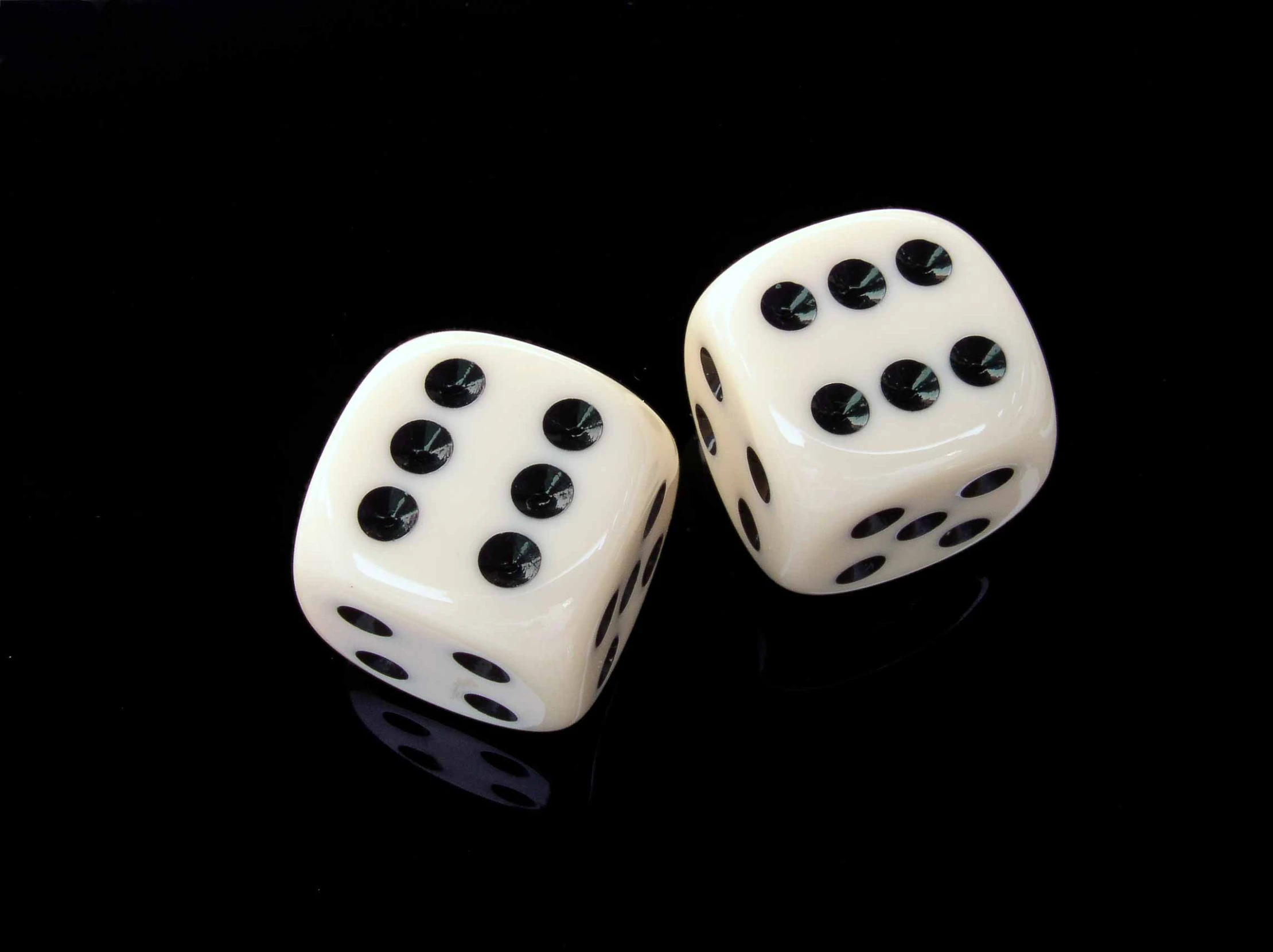 a pair of dice with black dots sitting on a table